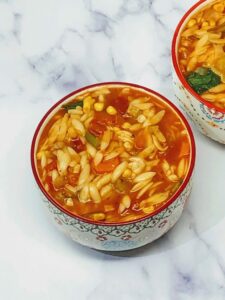 Orzo pasta soup served in a bowl.