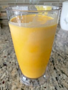 Mango pulp mixture in a tall container.