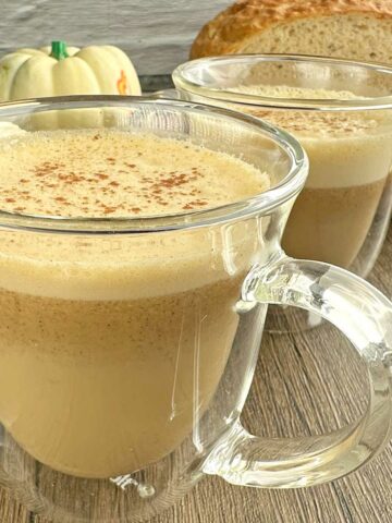 Pumpkin spice latte in couple of clear coffee mugs.