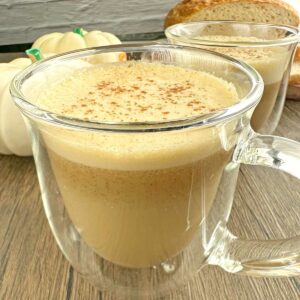 Pumpkin spice latte in couple of clear coffee mugs.