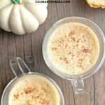 Pumpkin spice latte in couple of clear coffee mugs.