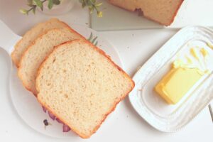 Slices of Greek Yougurt Bread on a platter with butter on the side.