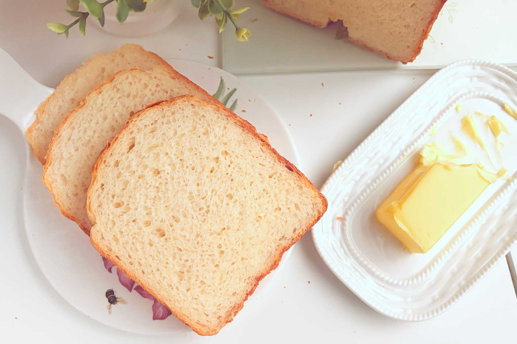 Slices of Greek Yougurt Bread on a platter with butter on the side.