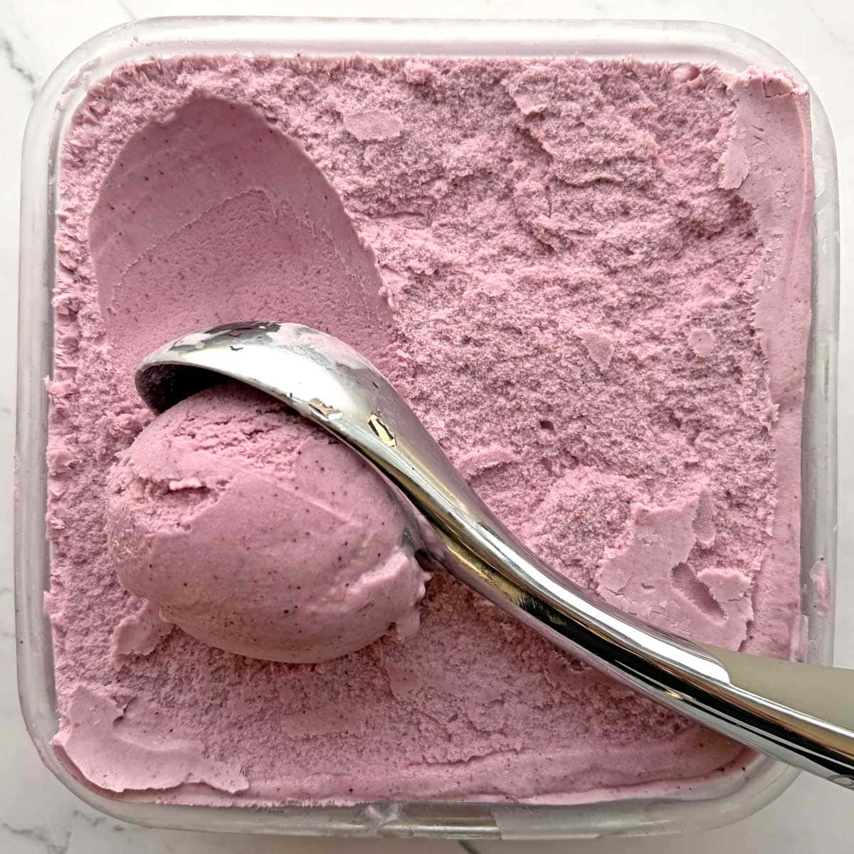 Mixed Berry ice cream scoop in a container.
