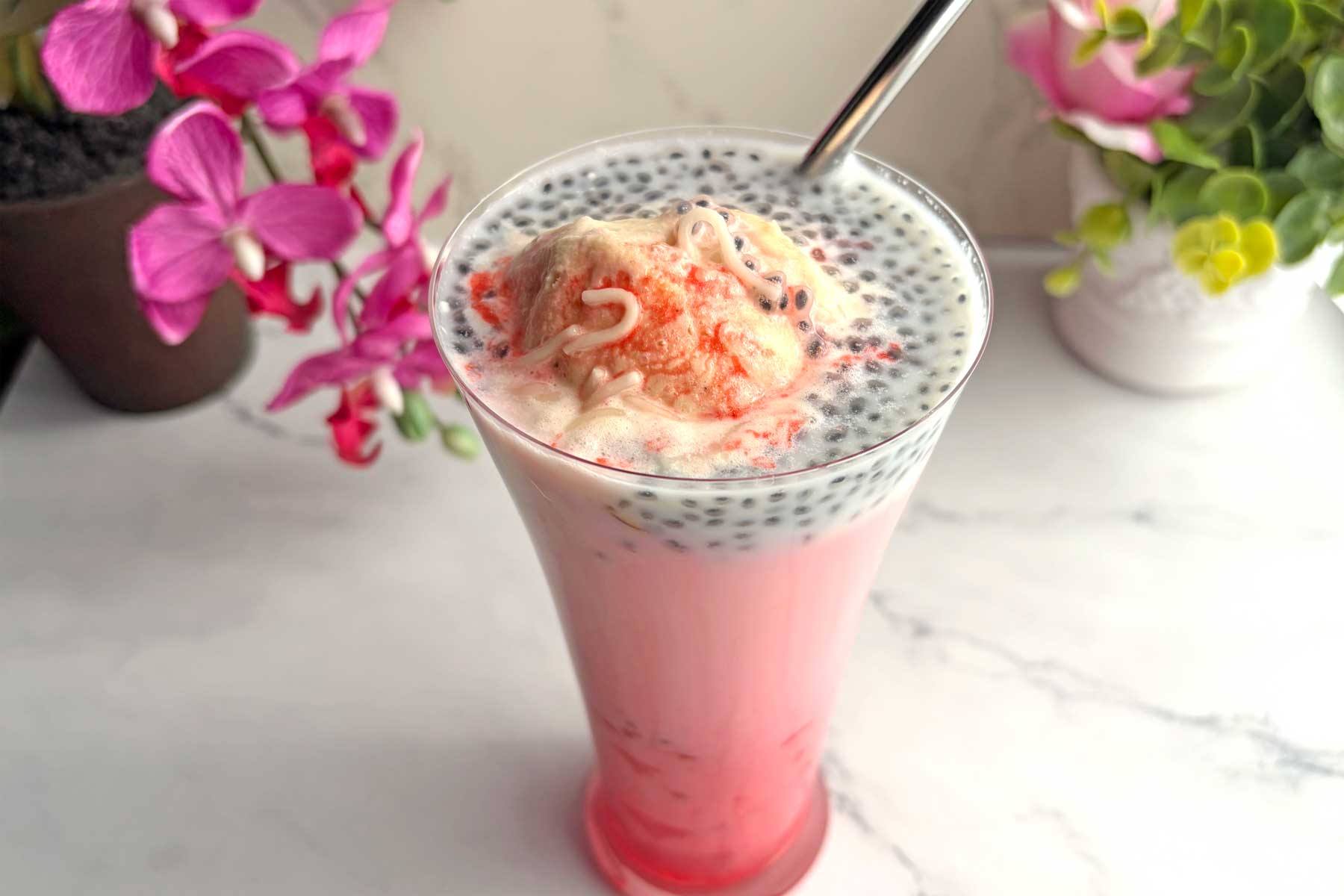 Falooda ice cream in a tall glass with straw.