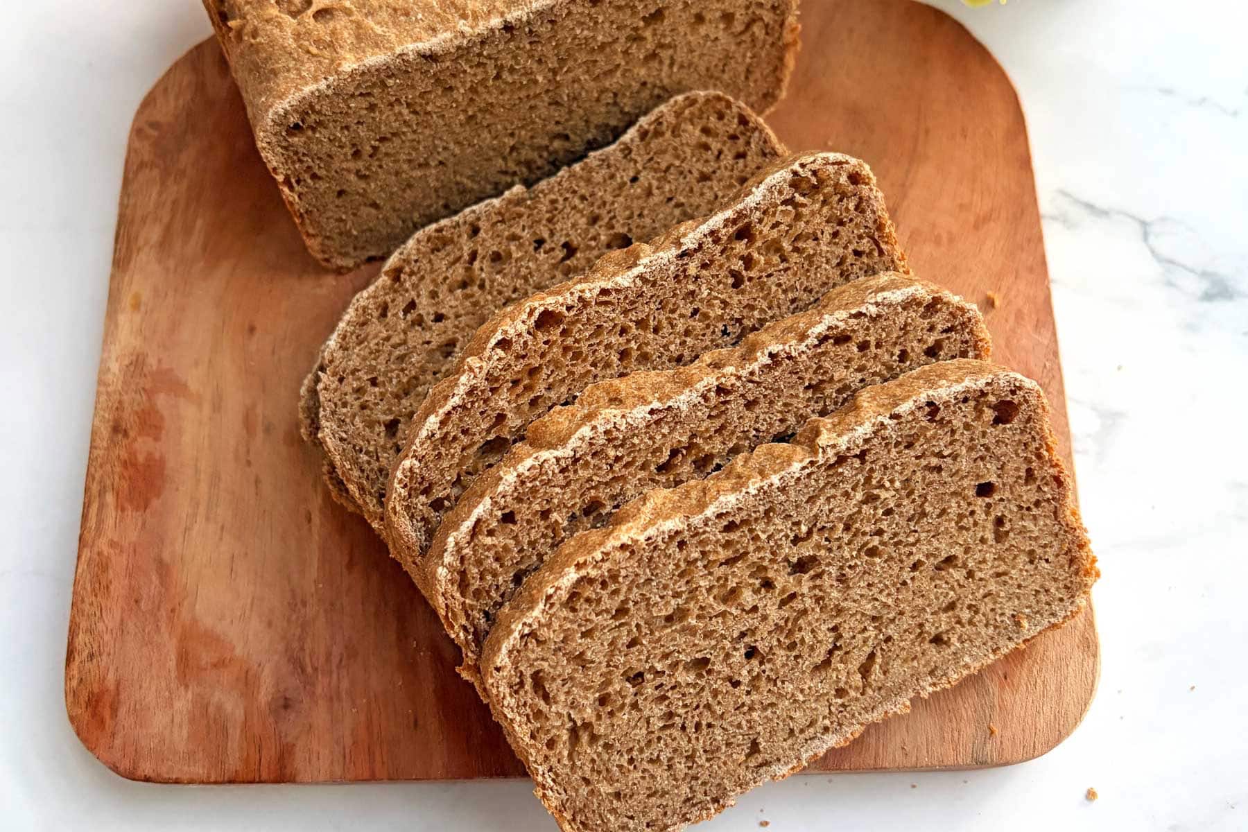 Sprouted wheat flour bread slices on a cutting board.
