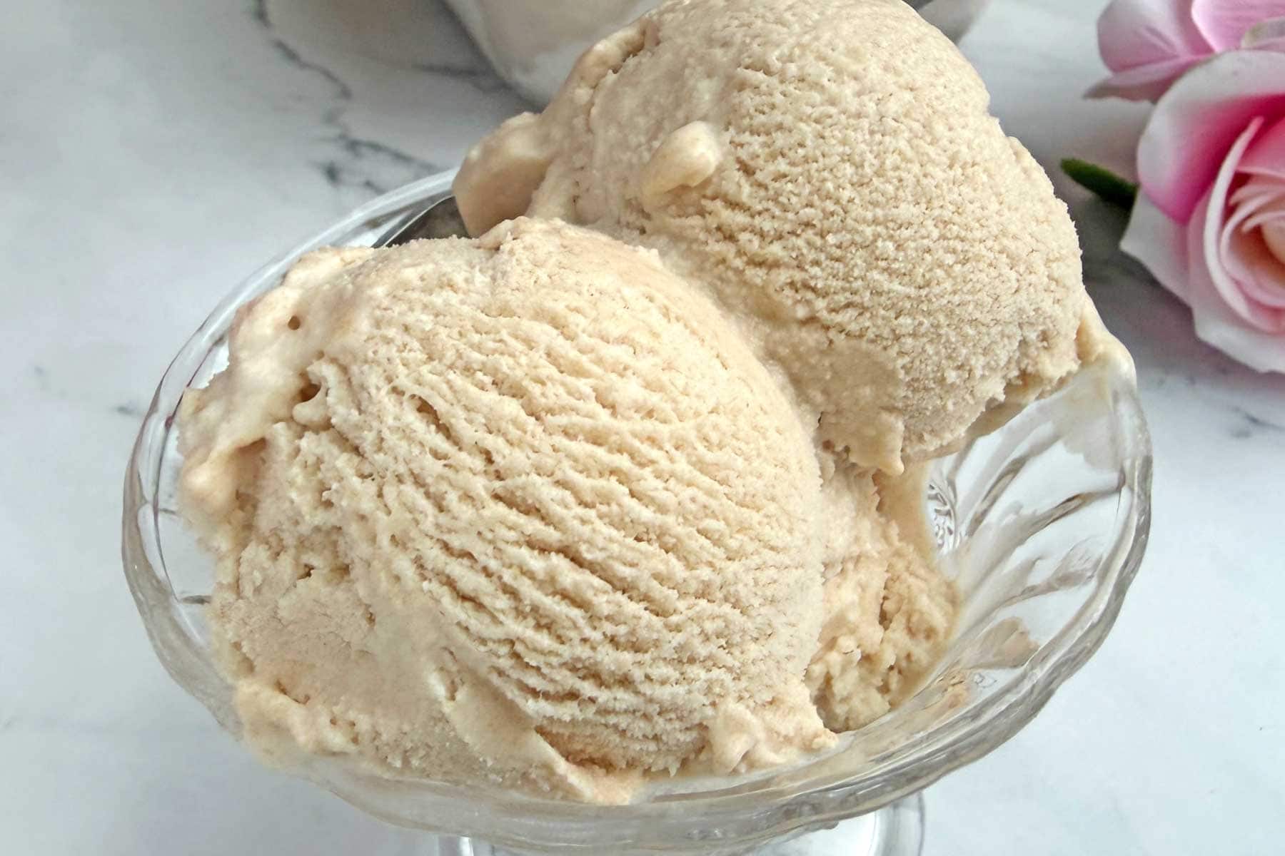 Chikoo ice cream scoops in a glass serving bowl.