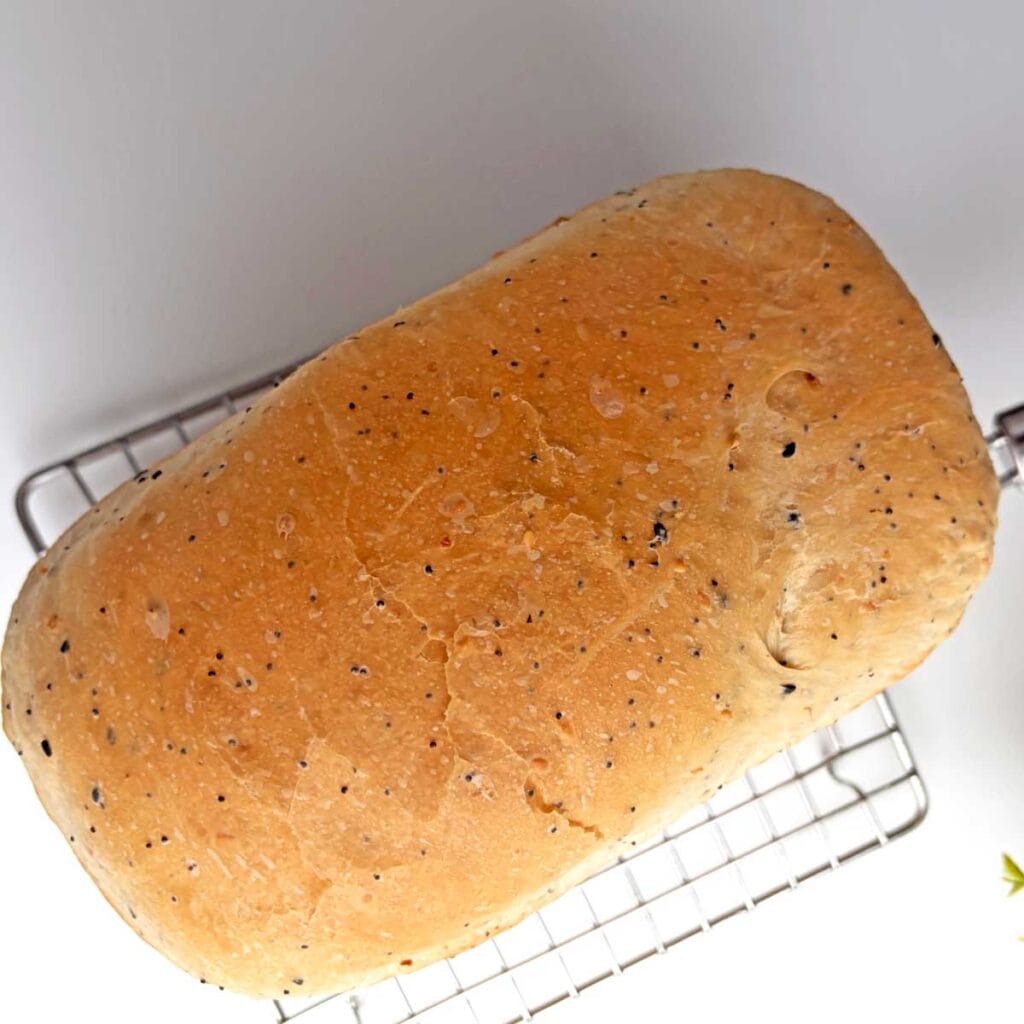 Everything Seasoning bread loaf on cooling rack.