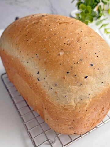 Everything Seasoning bread loaf on a cooling rack.