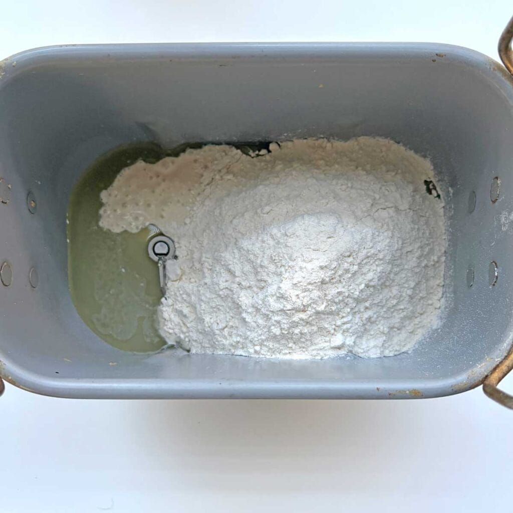 Sourdough dinner rolls ingredients in a bread pan.