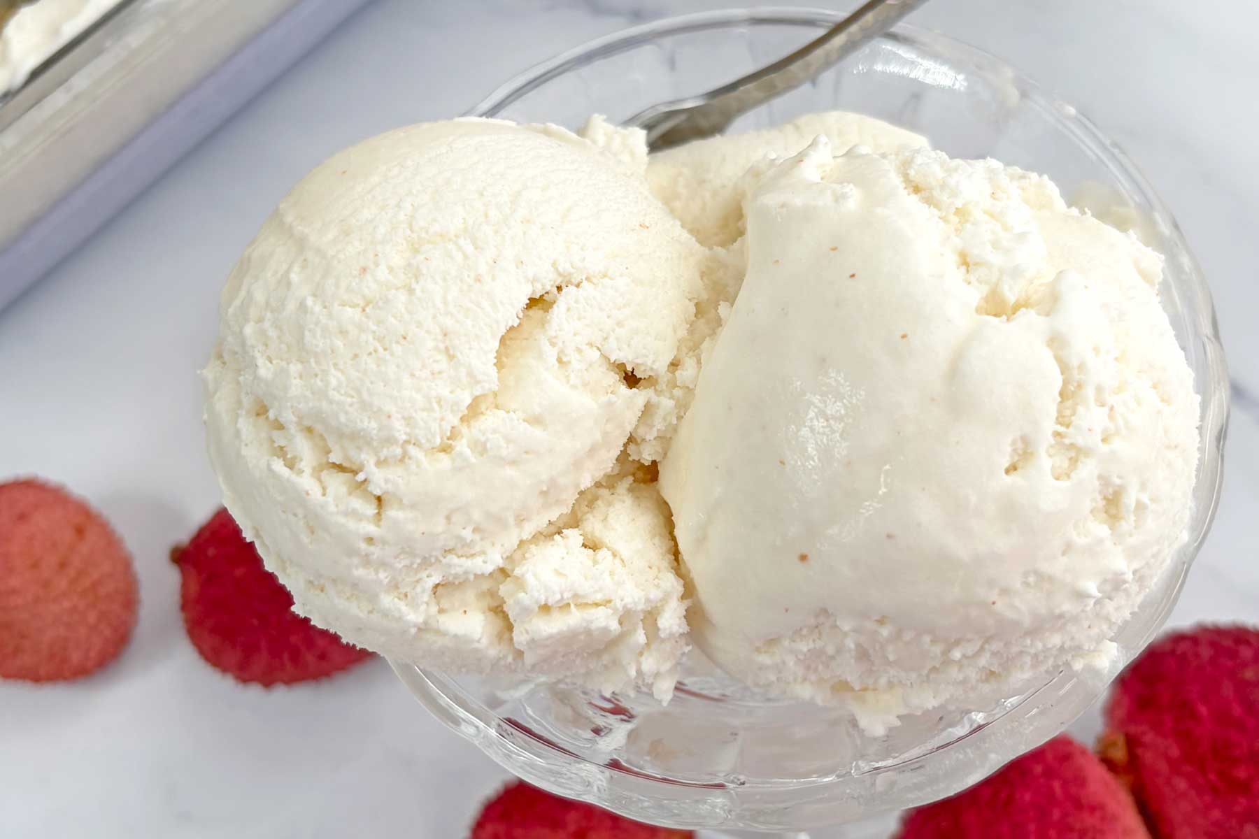 Lychee ice cream scoops in a serving bowl.
