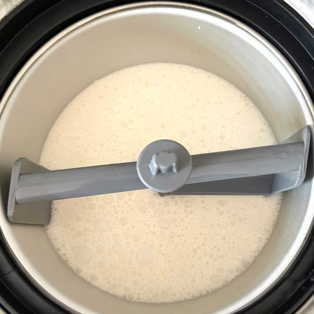Lychee ice cream mix in ice cream maker bowl.
